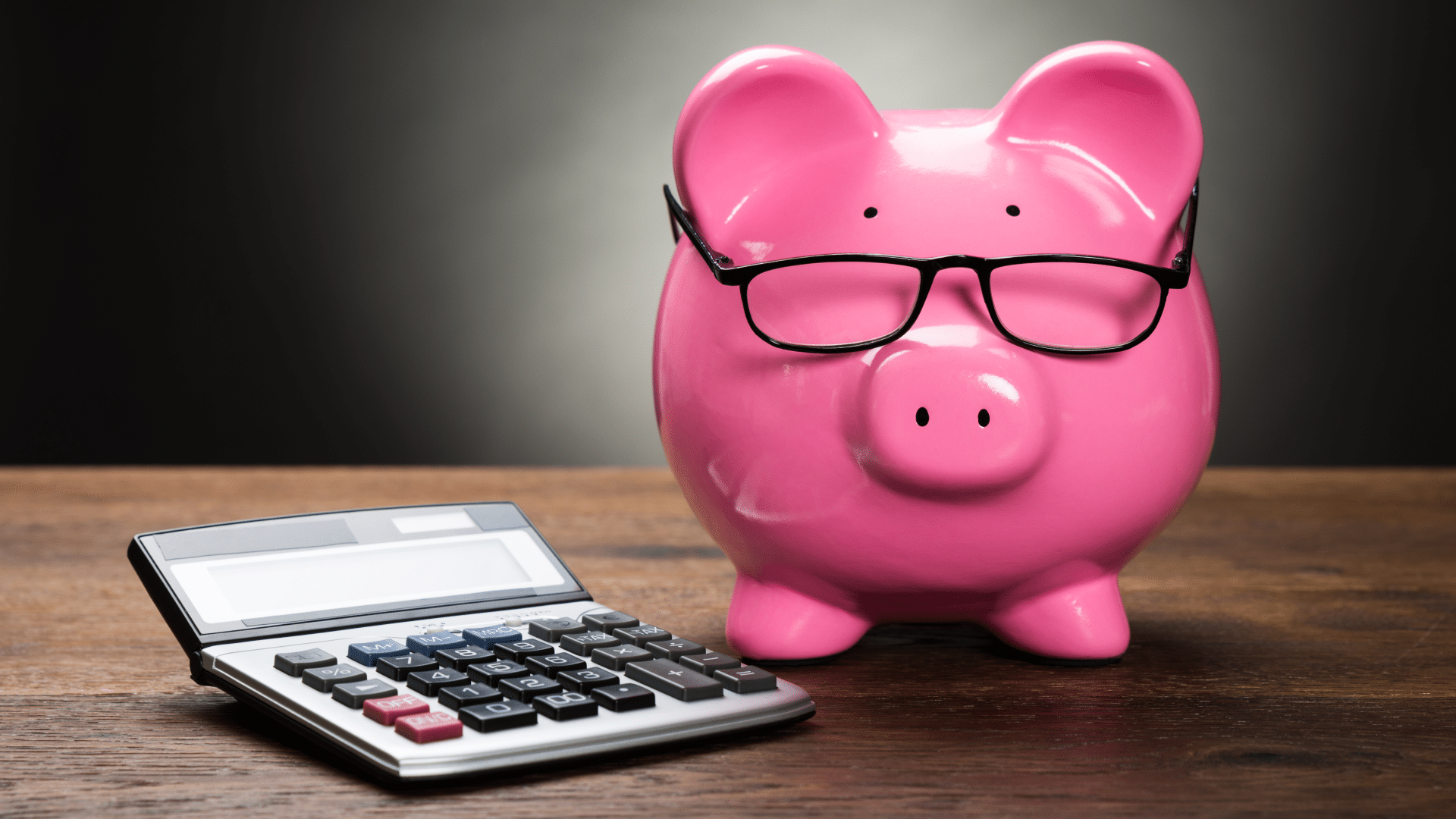 blog marketing - a piggy bank wearing glasses sits next to a calculator