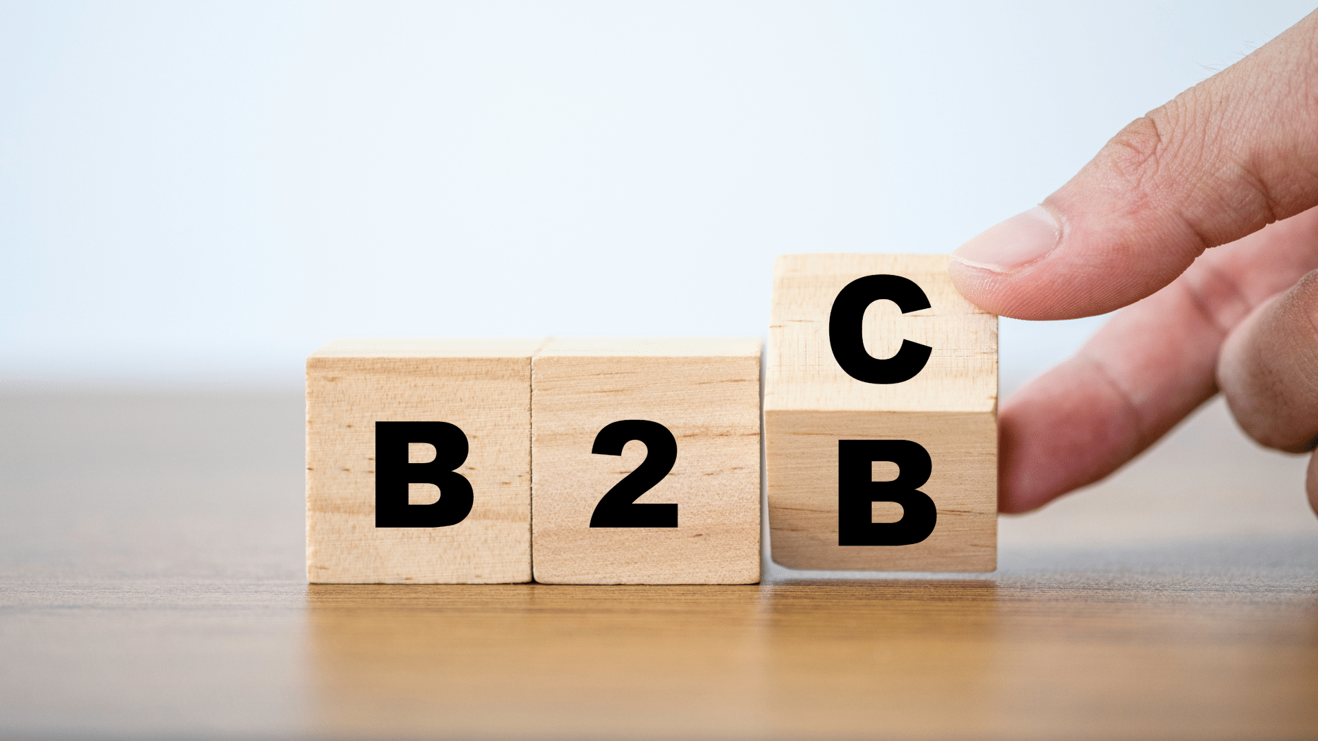a hand is flipping wooden cube blocks to change wording of B2B to B2C