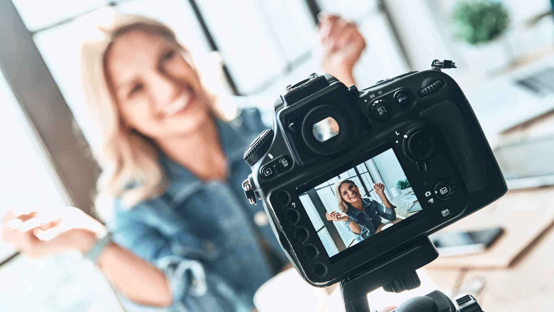 a woman is smiling for the camera while filming to show what brand ambassadors do